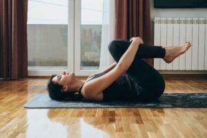 Woman_Practicing_Yoga_Knee_To_Chest_Pose