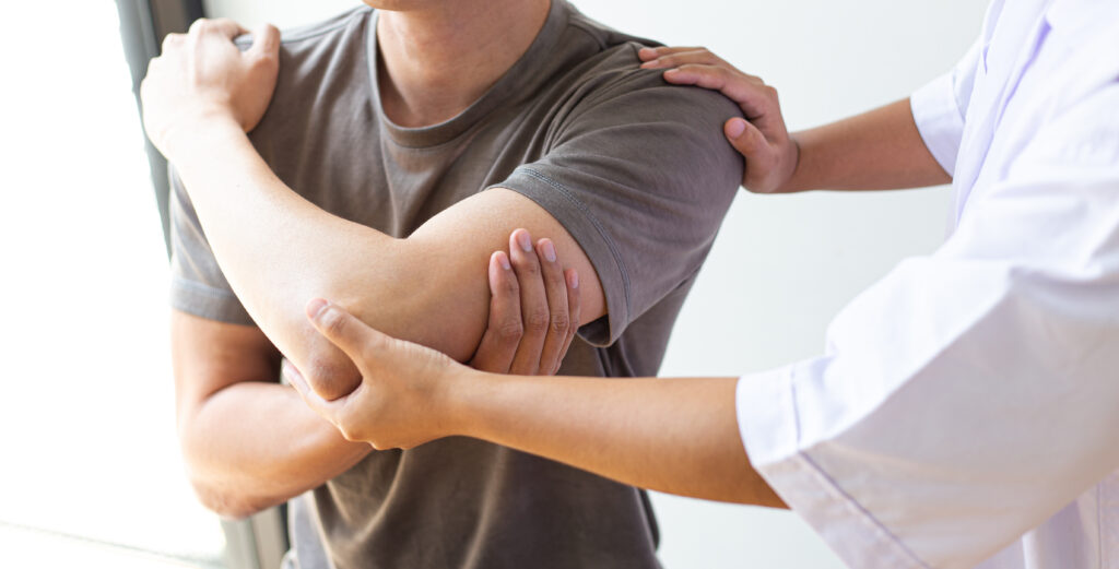 Physio helping a man with a sore shoulder in rehabilitation