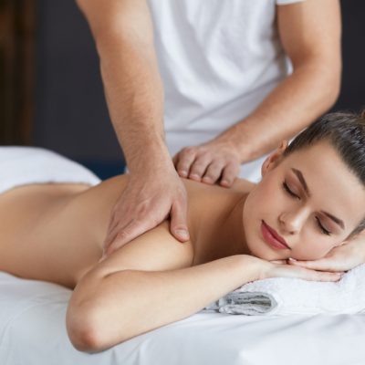 Young beautiful woman enjoying back and shouders massage